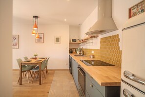 Una cucina moderna con piani in legno, forno a incasso e zona pranzo con tavolo e sedie.