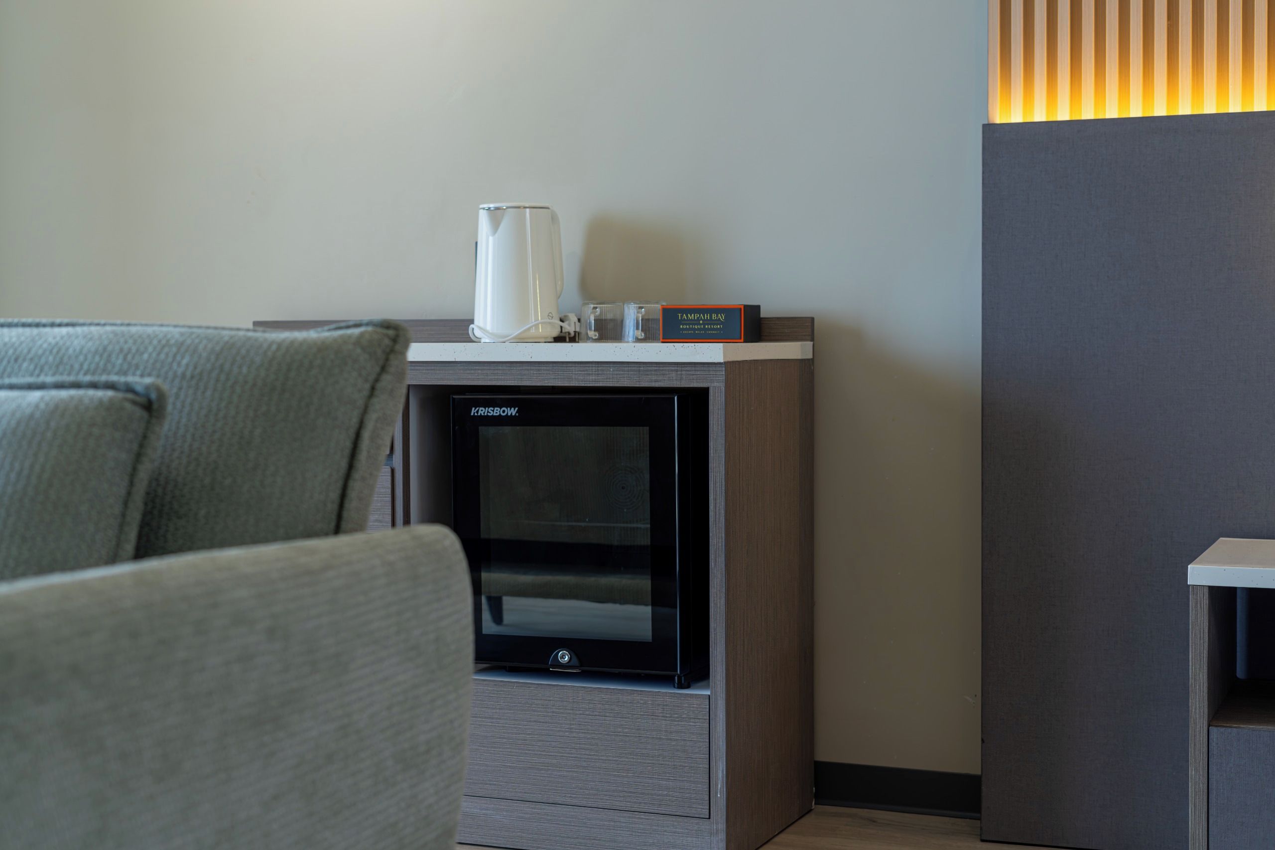 Una habitación moderna con chimenea integrada, cafetera y un cartel que dice Tampah Bay Boutique Resort.