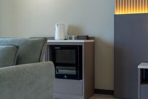 Una habitación moderna con chimenea integrada, cafetera y un cartel que dice Tampah Bay Boutique Resort.
