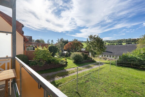 Il s’agit d’une propriété résidentielle dotée d’un balcon donnant sur un jardin bien entretenu et offrant une vue dégagée sur le paysage environnant.