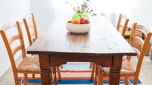 Ein Holztisch mit einer Obstschale und einer Blumenvase.