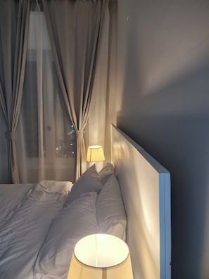 A hotel room with a bed, a bedside lamp, and sheer curtains. - 3BRs Garden City Lexus Living (Cairo Governorate)