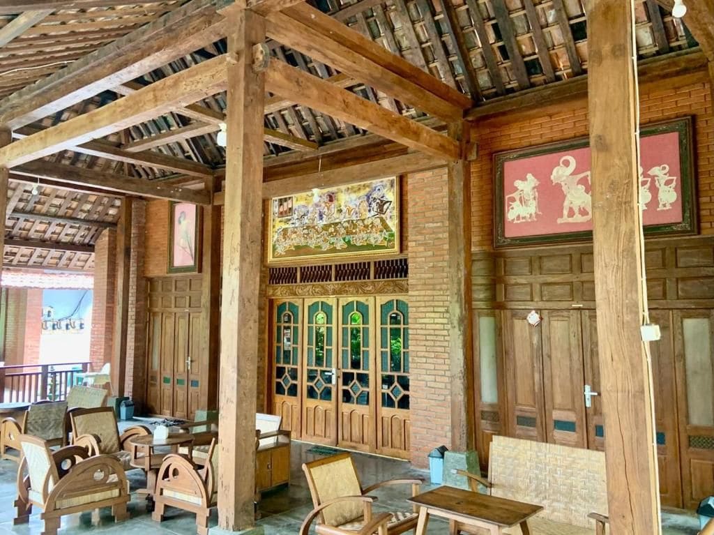 A wooden interior with a high ceiling, wooden furniture, and decorative panels.