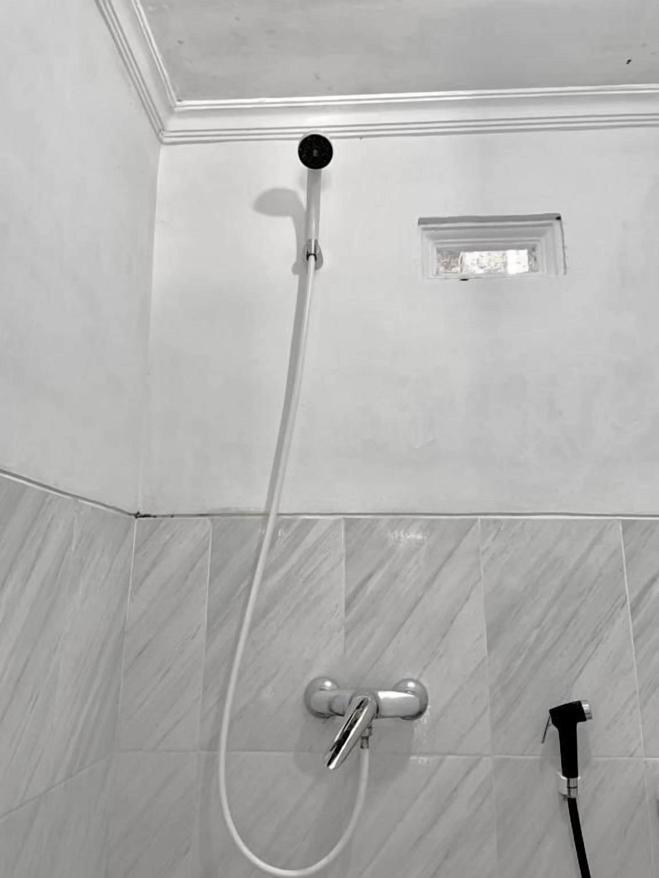 Ducha con cabezal de ducha de mano y grifo empotrado.