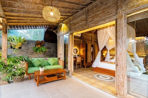 A room with a green sofa, wooden coffee table, and potted plants. - Pondok Padi Bali Villa (Taro)