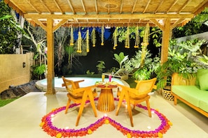 An outdoor patio with a pool, surrounded by lush greenery and a wooden pergola. - Pondok Padi Bali Villa (Taro)
