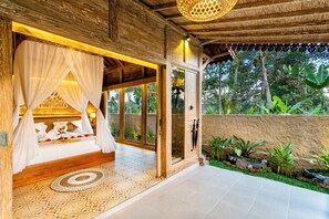 Una habitación con cama, dosel y vistas al jardín.