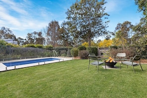 A backyard with a swimming pool, a fire pit, and outdoor seating. - KARINYA LODGE - The Vintage Holiday Houses (POKOLBIN)