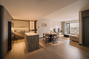 Ein moderner Wohnraum mit Küche, Essbereich und Sitzecke mit Blick auf die Stadt.