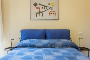 Ein Schlafzimmer mit einem Bett, zwei Nachttischen und einem Wandbild.