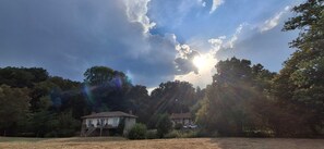 A house with a porch and a car parked in front, surrounded by trees and a clear sky. - Country House 'Your Riverside Mill' with Private Terrace, Private Garden and Wi-Fi (Saint-Priest-sous-Aixe)