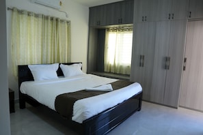 Un dormitorio con cama, cortinas, ventana y armario.