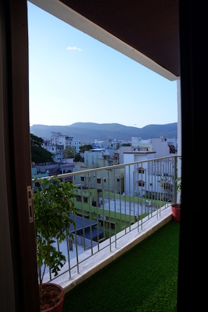 Ein Balkon mit Blick auf ein Wohngebiet und ferne Berge.