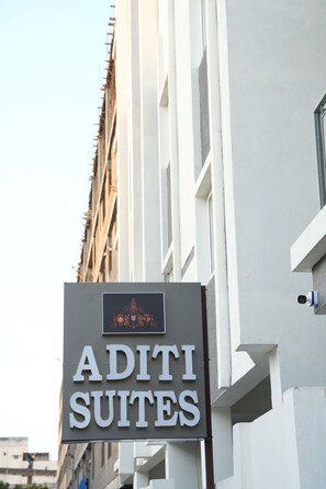 Un letrero que dice 'Aditi Suites', con un logotipo encima del texto.