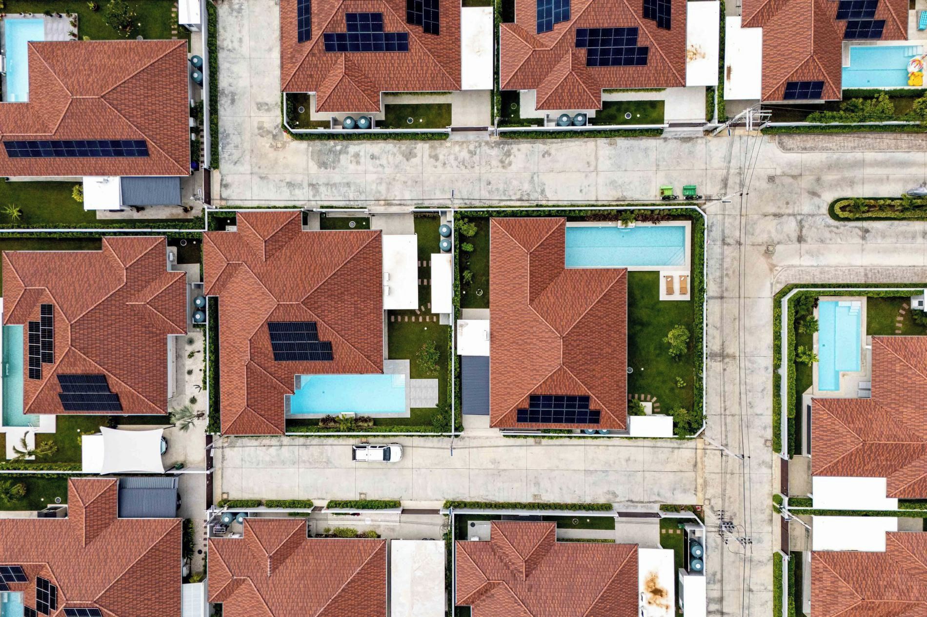 Zona residencial con varias casas de techos a dos aguas y paneles solares.
