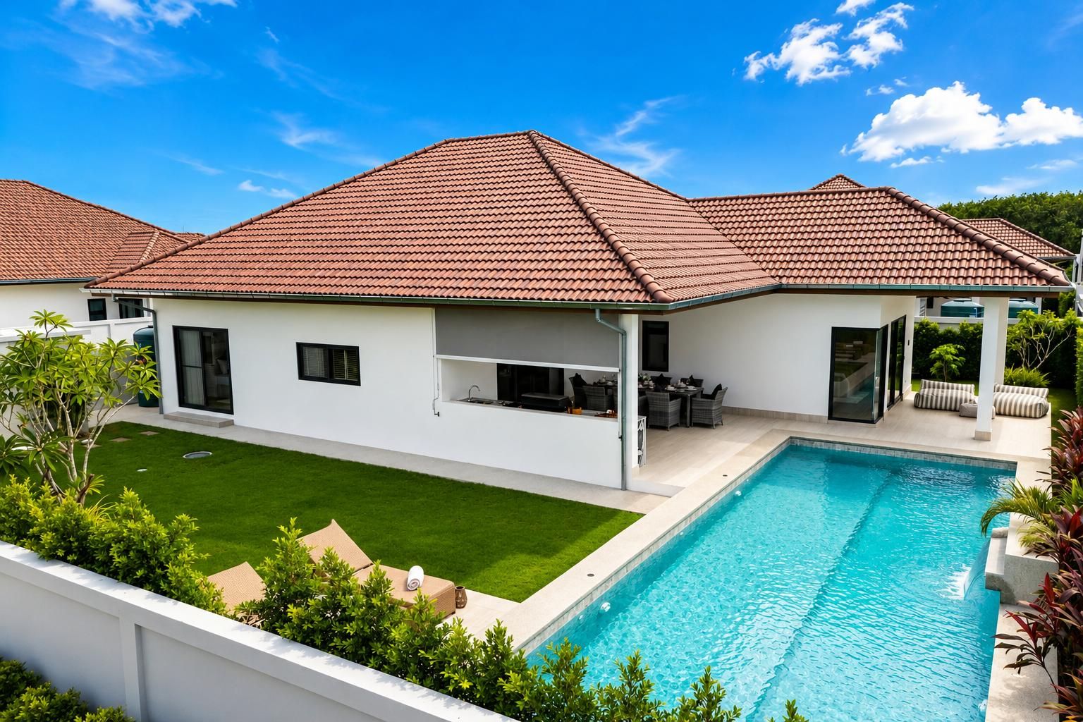 Une maison moderne dotée d’une piscine, d’un patio couvert et d’une pelouse bien entretenue.