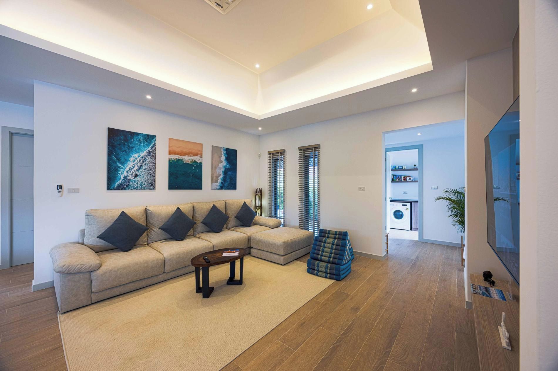 Uma sala de estar moderna com sofá seccional, mesa de centro e obras de arte na parede.
