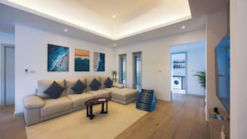 Uma sala de estar moderna com sofá seccional, mesa de centro e obras de arte na parede.