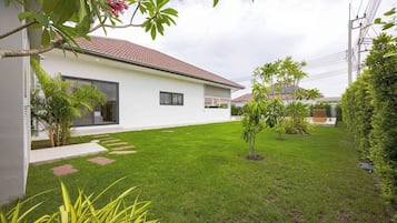 Ein modernes Haus mit gepflegtem Rasen, einer Terrasse und Blick auf die Nachbarschaft.