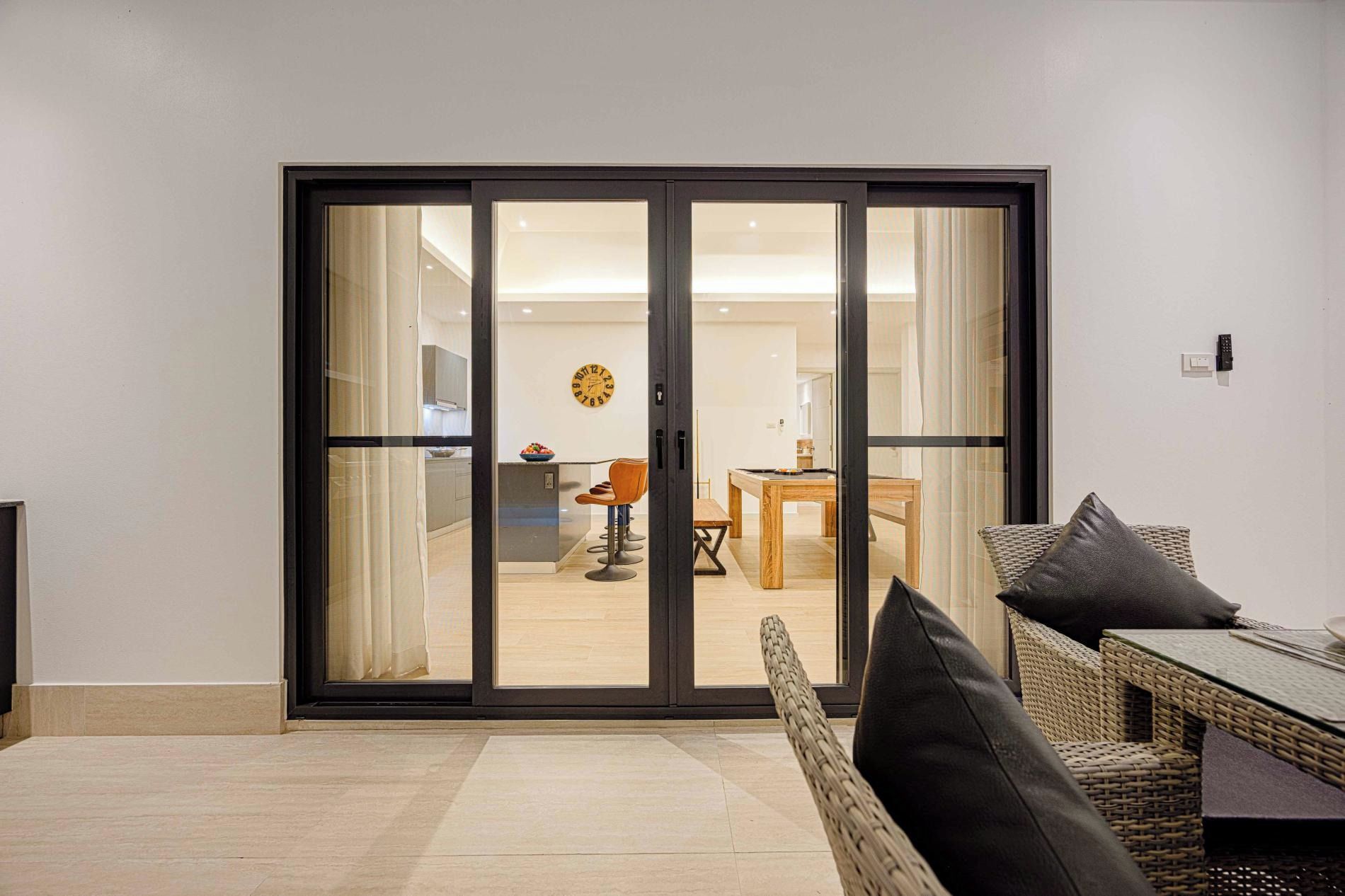 Una sala de estar moderna con un puertas correderas de vidrio que dan a un comedor.