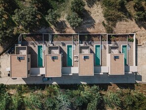 A row of four individual rooms with separate entrances, each with a small window and a door.
