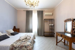 A bedroom with a bed, a wooden dresser, a mirror, and a window with curtains. - Casa Musy . (Isola Sacra)
