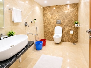 A modern bathroom with a large white sink, a toilet, and a shower area. - Hotel Twin Fountains - near Main Places (Calangute)