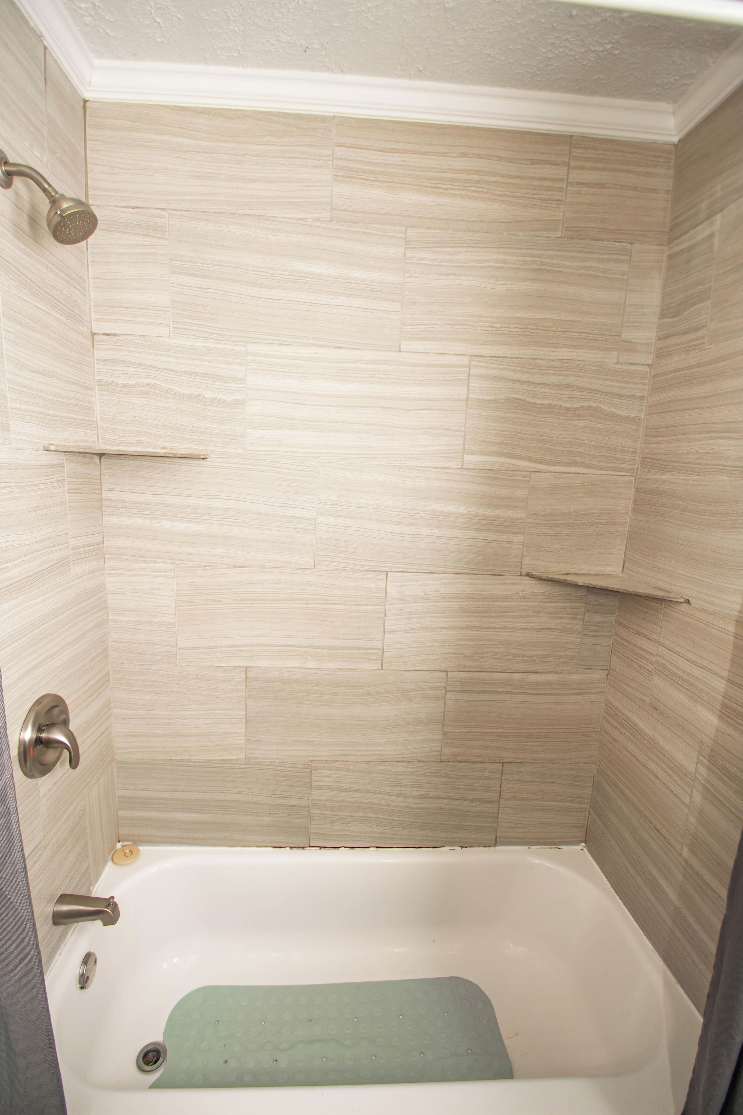 A bathroom with a bathtub, a showerhead, and a toilet.