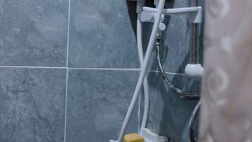 Un baño con ducha, panel de control y cabezal de ducha de mano.
