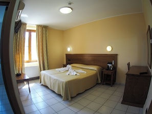 A hotel room with a bed, bedside table, and a nightstand with a telephone. - Hotel Ristorante da Santina (Castro dei Volsci)