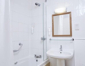 A bathroom with a glass shower enclosure, a white sink, and a mirror with a wooden frame. - The Dog House (Abingdon)