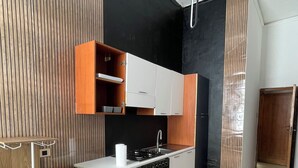 A modern kitchen with a gas stove, oven, and wooden cabinets. - Vrbo Property (Lamezia Terme)
