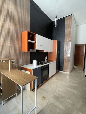 A modern kitchen with a gas stove, oven, and wooden cabinets. - Vrbo Property (Lamezia Terme)