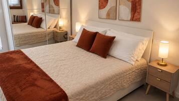 A neatly made bed with a brown blanket, bedside lamps, and artwork on the wall.