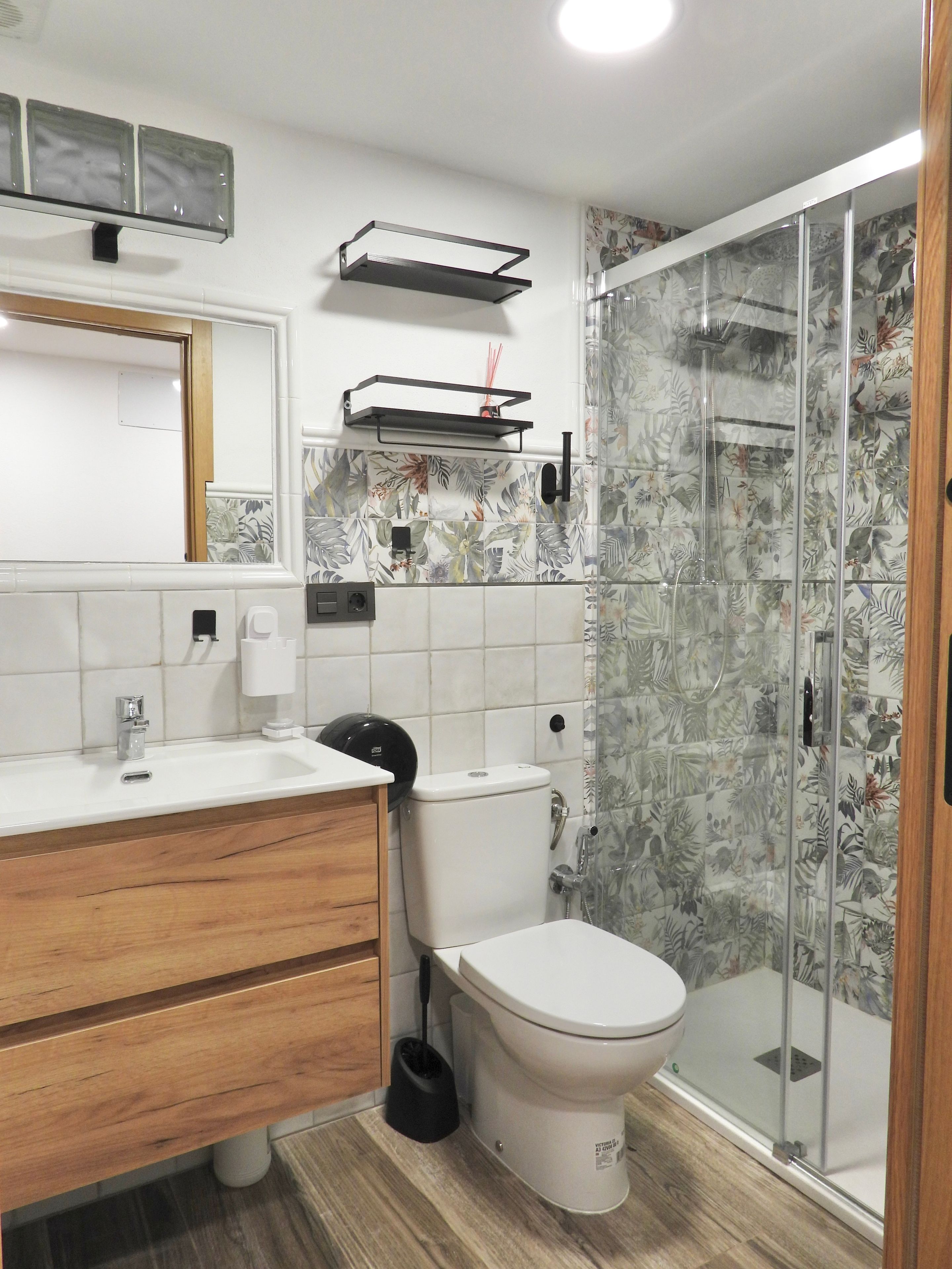 A bathroom with a toilet, sink, and shower.