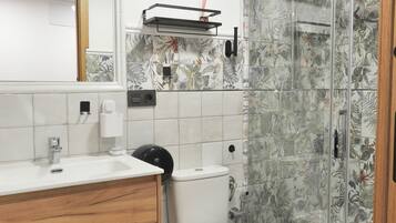 A bathroom with a toilet, sink, and shower.