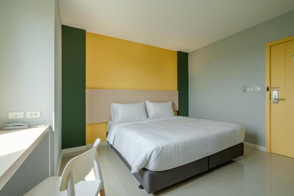 Una habitación de hotel moderna con una cama, un escritorio y una silla.