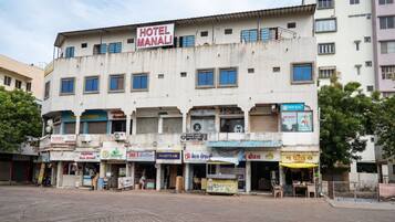 A multi-story building with a sign for 'HOTEL MANALI' on the top.