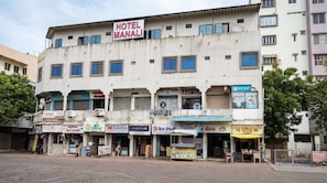 A multi-story building with a sign for 'HOTEL MANALI' on the top.