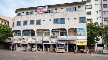 Un edificio de varios pisos con un letrero que dice 'HOTEL MANALI' en la parte superior.