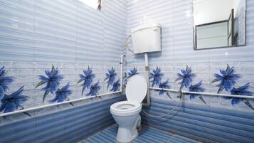 Un baño con inodoro, tanque blanco y espejo en la pared.