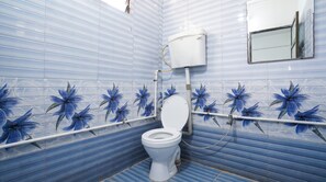 Un baño con inodoro, tanque blanco y espejo en la pared.