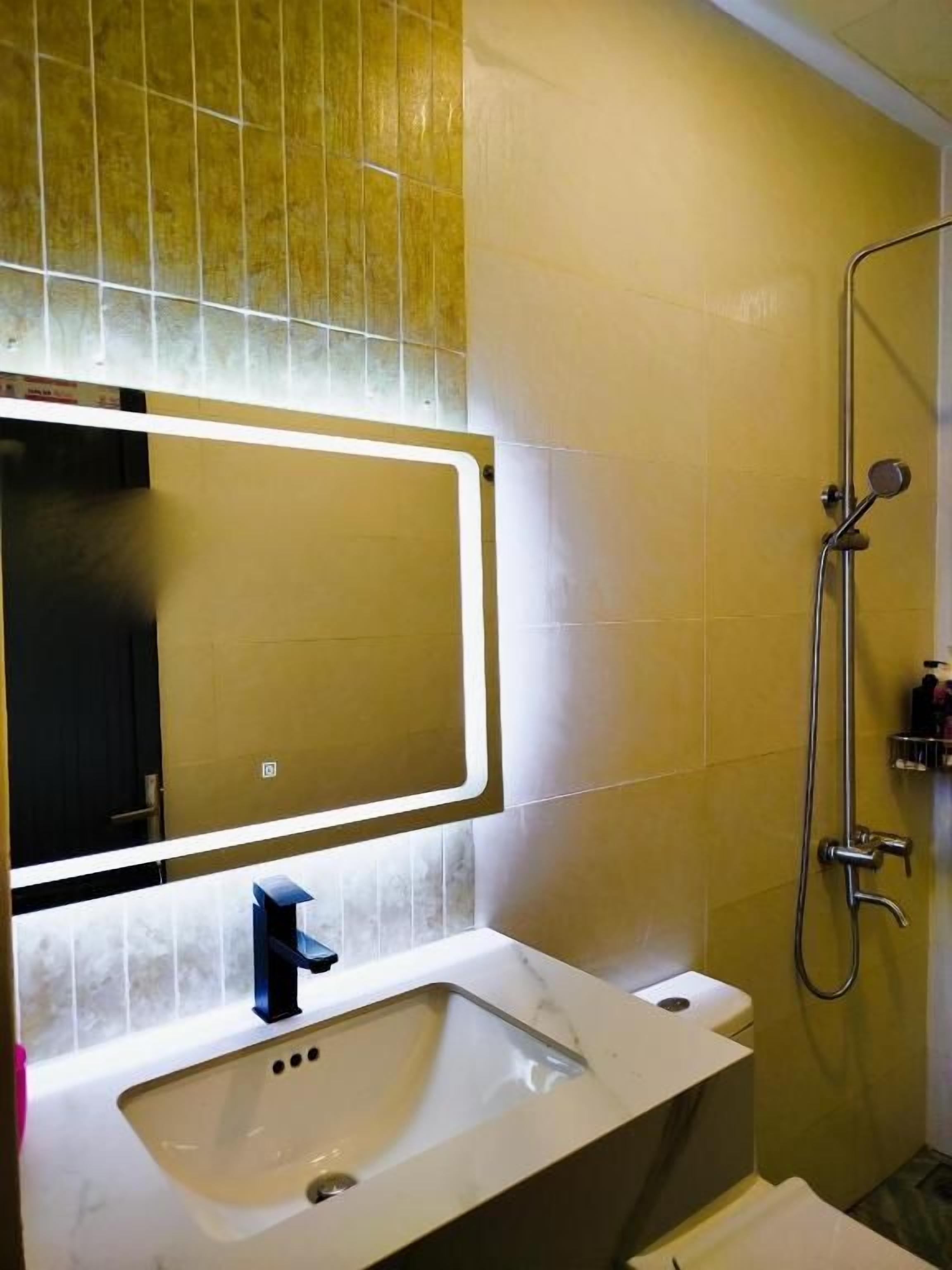 A bathroom with a white sink, a mirror, and a shower.