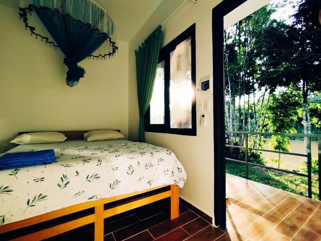 Un dormitorio con cama, ventana y vista a zonas verdes.