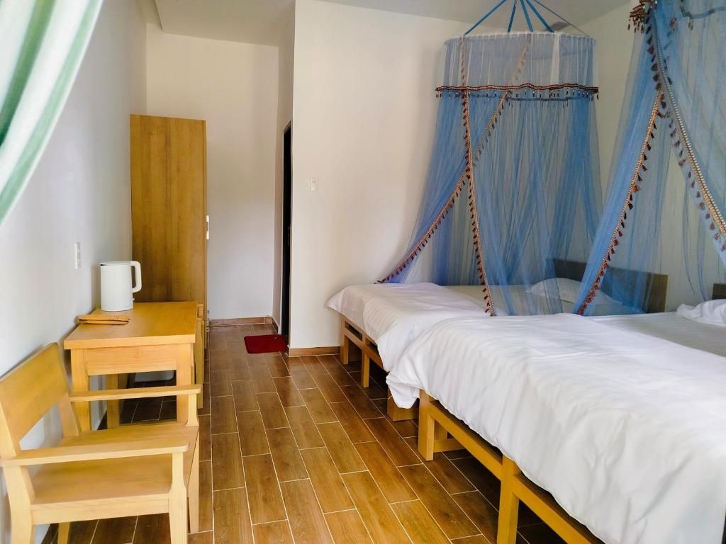 A room with a bed, a wooden bench, a table, and a wardrobe.