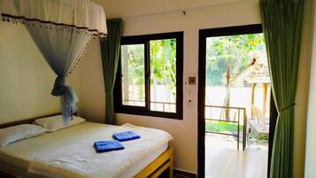 A bedroom with a bed, a window, and a view of the outdoors.