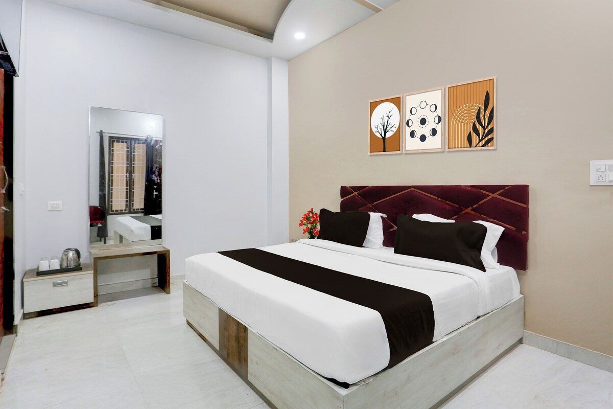 Una habitación de hotel con cama, mesita de noche, espejo y decoración en la pared.