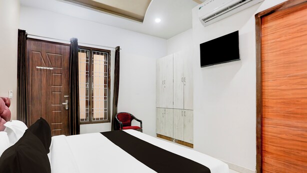 A hotel room with a bed, a wardrobe, a chair, and a television. - OYO Hotel O Bareilly Near Bus Stand (Bareilly)