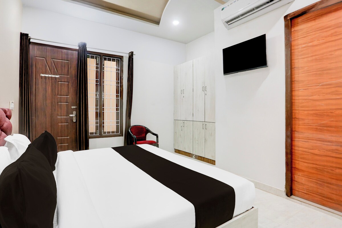 A hotel room with a bed, a wardrobe, a chair, and a television.
