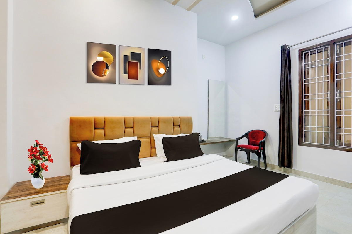 Habitación de hotel con una cama grande, un escritorio, una silla y tres obras de arte colgadas en la pared.
